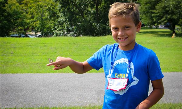 Boy holds out butterfly